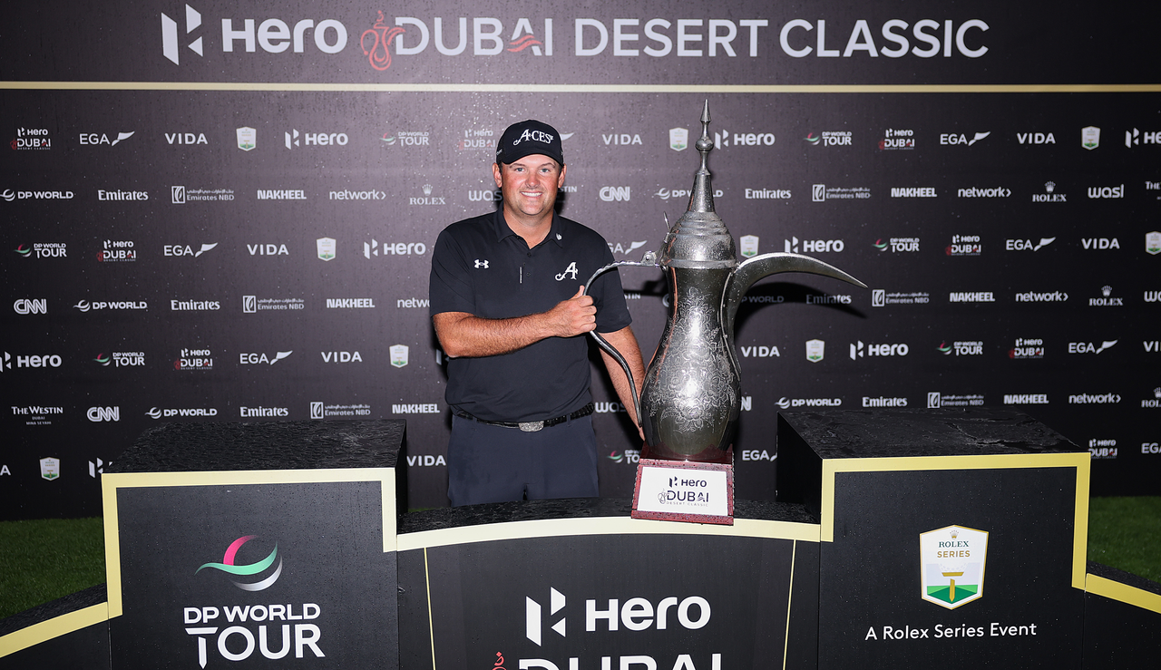 Patrick Reed poses next to the Dubai Desert Classic trophy