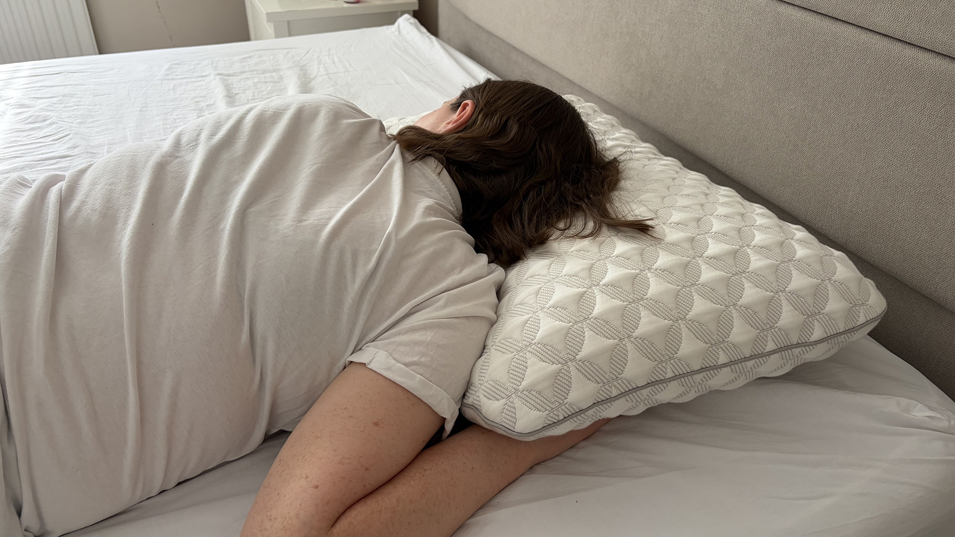 Pillow tester Ruth Jones lies on her stomach with her head resting on the Helix Talalay Latex pillow