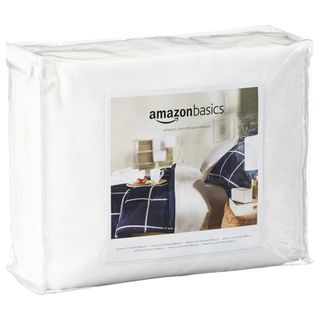The Amazon Basics Mattress Protector in its bag on a white background