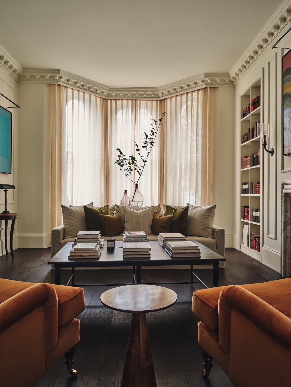 A contemporary living room with books on the coffee table and on fitted shelving
