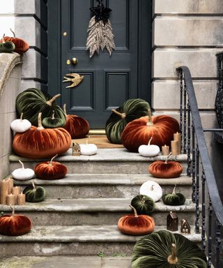 halloween decor ideas, front door with velvet pumpkins on the steps with candles and mini house tea lights