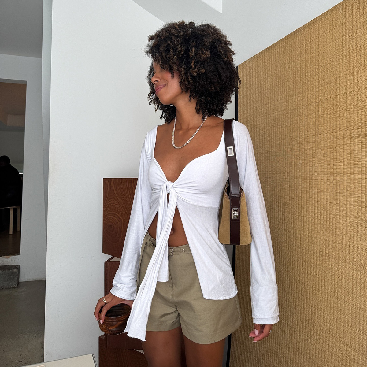 Influencer wearing a white top and tan A-line shorts