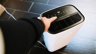 person switching on a dehumidifier