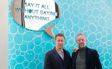 Jeppe Hein and Adam Byatt in front of Jeppe Hein artwork with a speech bubble mirror that says "Say it all without saying anything". 