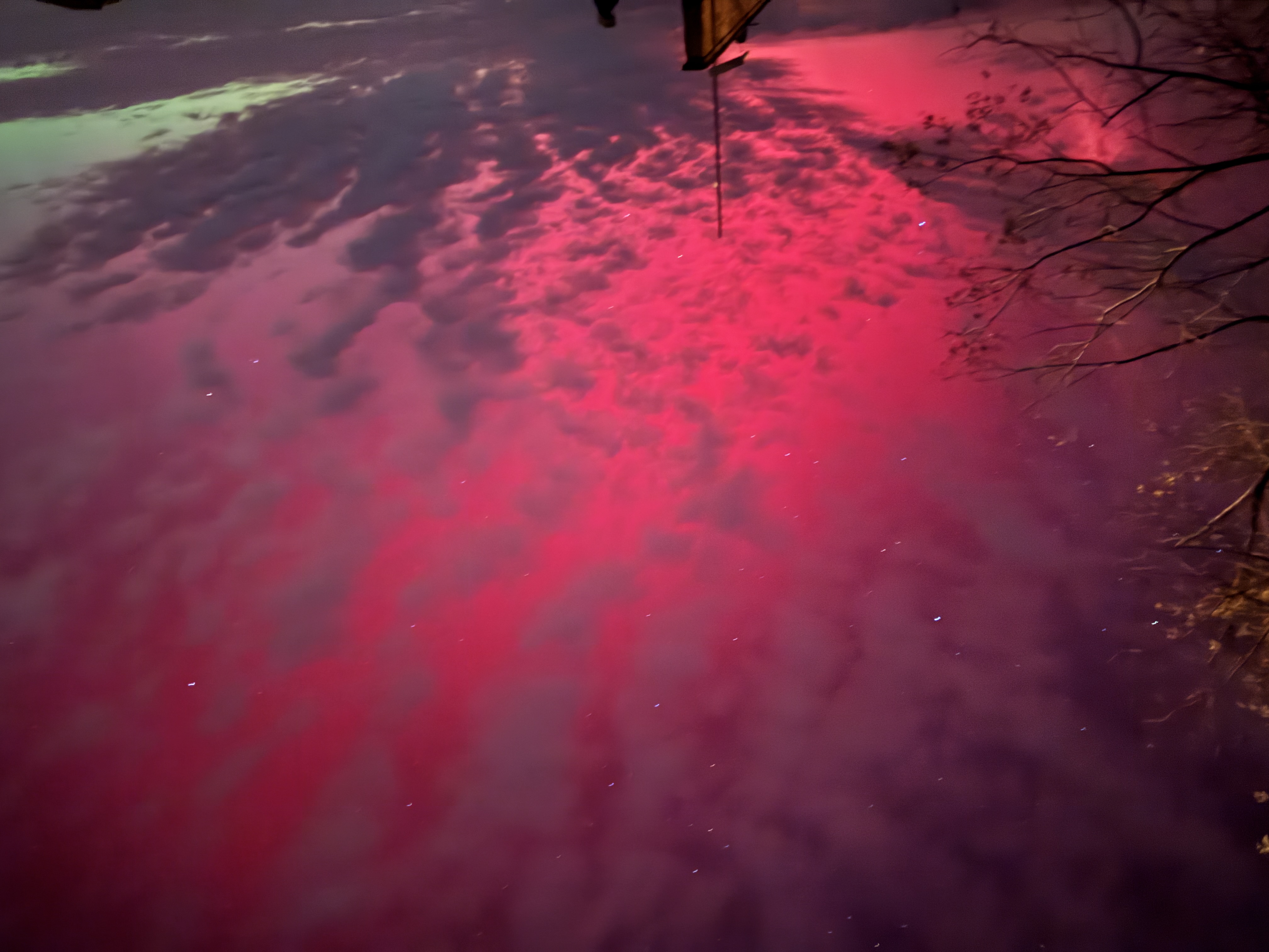 北極光在天空中呈現為紅色和綠色光幕。