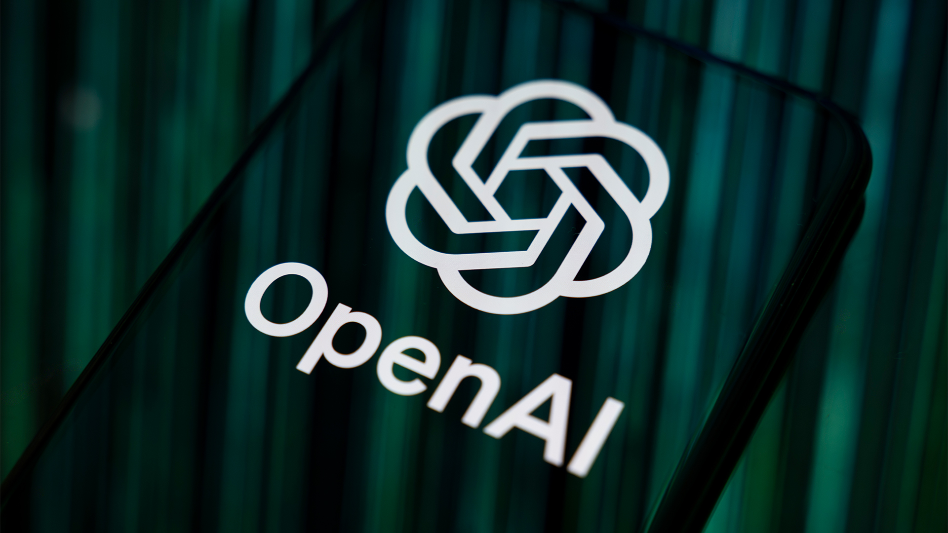 Close-up image of OpenAI logo and branding displayed on a smartphone screen. 