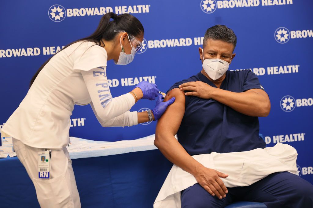 Leonida Lipshy, RN in the COVID unit at the Broward Health Medical Center, gives Jaime Carrillo, M.D. Internal Medicine, Broward Health Imperial Point, a shot of the Moderna COVID-19 vaccine 