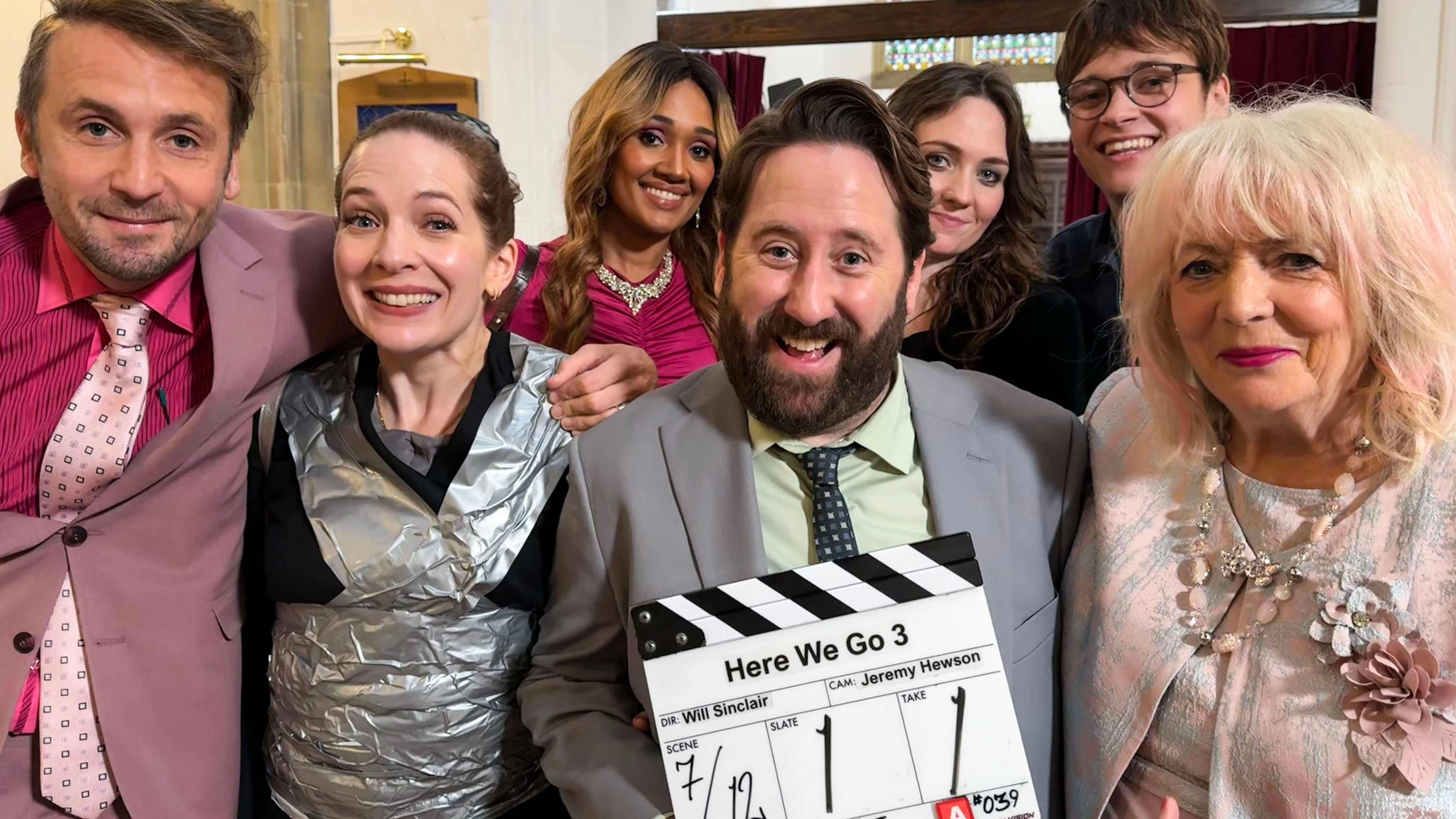 The stars of Here We Go pictured with a clapperboard for series three