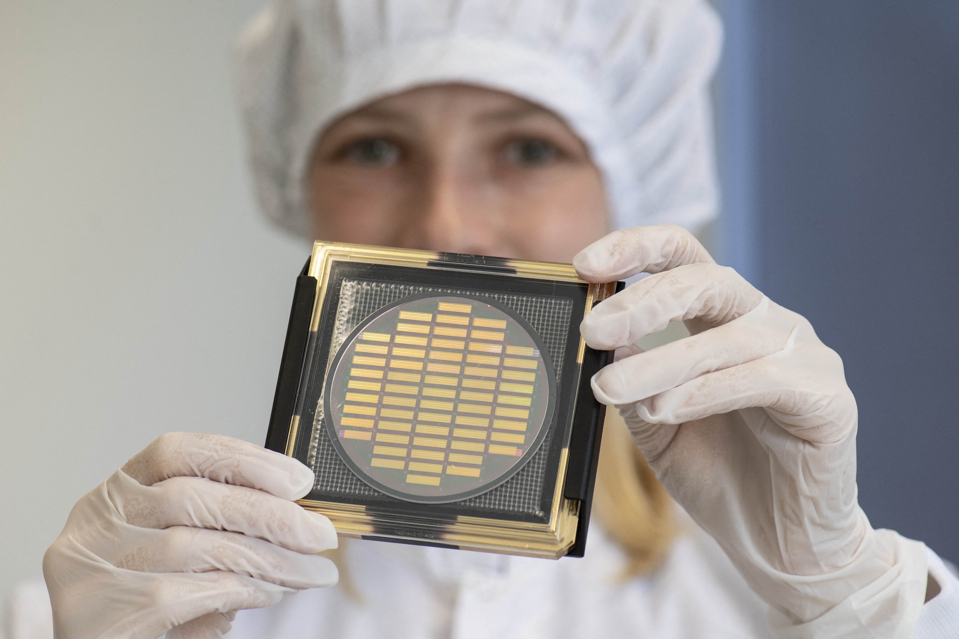 a person holds up a photonic computer chip