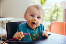 A baby in a high chair with food around its mouth