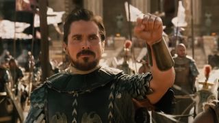 Christian Bale dressed as a Roman and holding gup a fist in Exodus: Gods and Kings