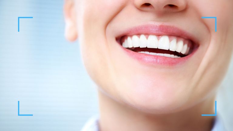 woman displaying white teeth on a blue background