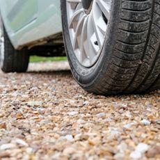Close up of car wheel on gravel driveway