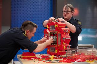 The LMFD (LEGO Masters Fire Dept.) intergalactic fire station is seen under construction by firefighters Stephen Joo and Stephen Cassley on "LEGO Masters."