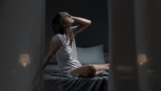 A woman struggling to sleep in a hot room