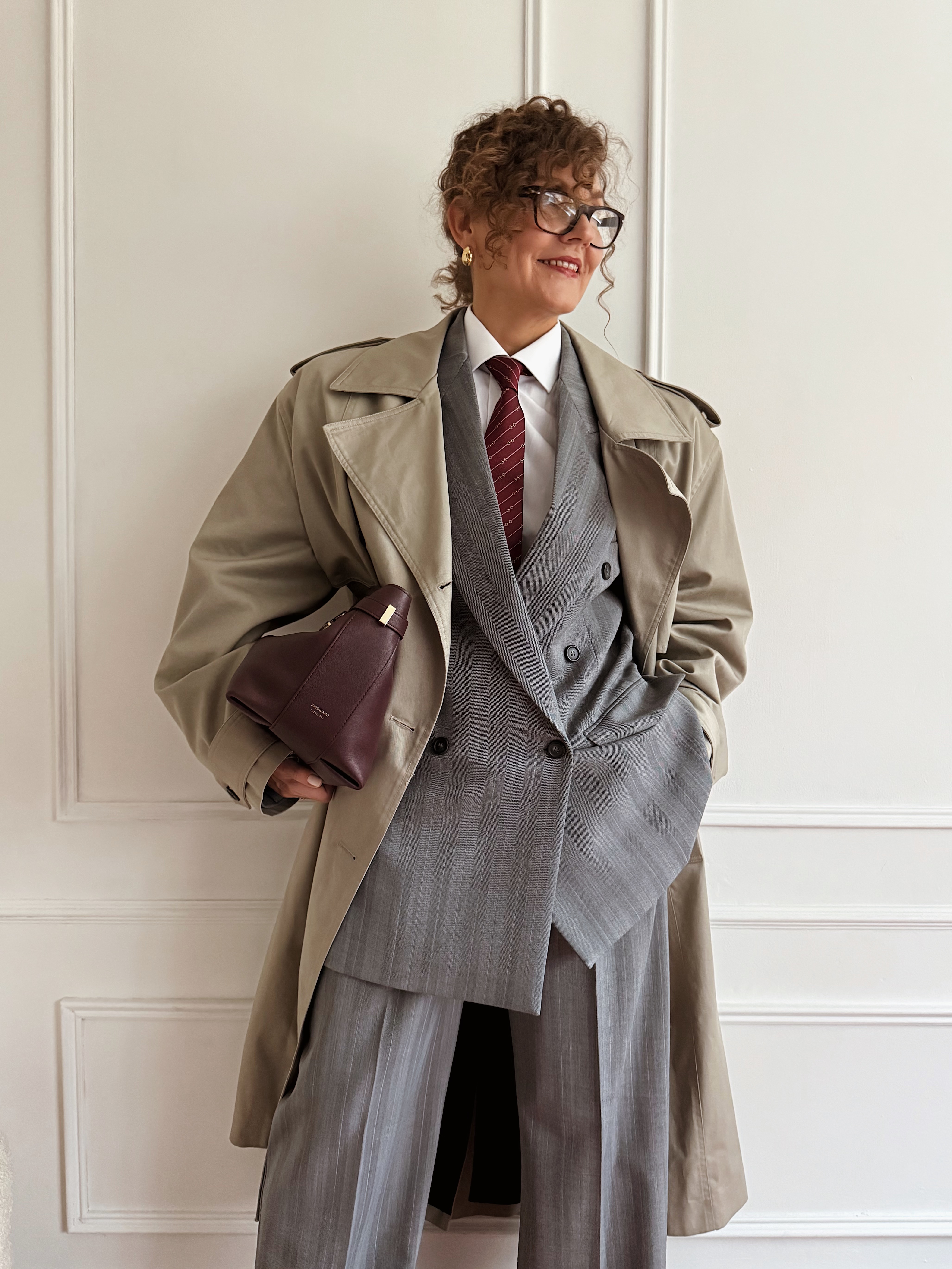 Renia Jazdzyk wearing a work outfit for mature women&amp;mdash;a suit, white shirt, red tie, and trench coat.