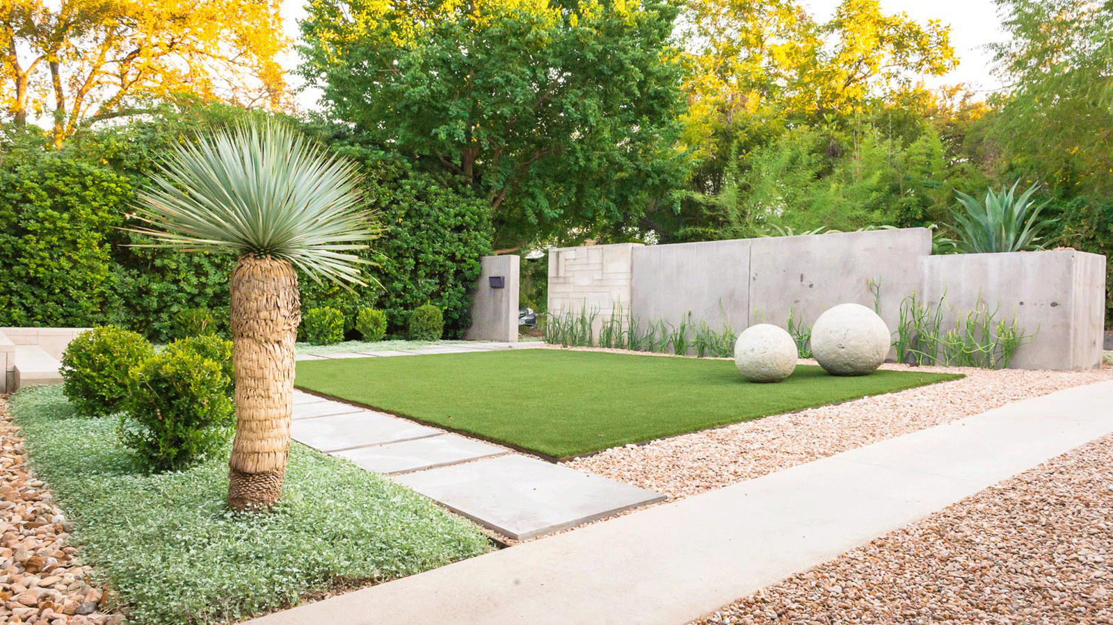 modern landscaped urban back yard with stone sculpture
