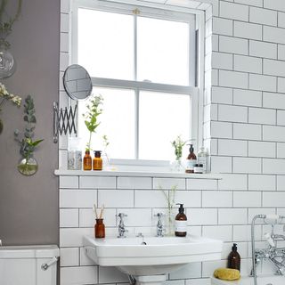 washroom with white tiles wall and white washbasin