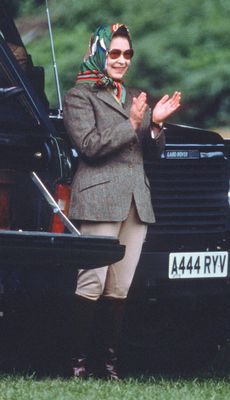 Queen Elizabeth ll, wearing jodhpurs and a headscarf, relaxes during Windsor Horse Show on May 13, 1988 in Windsor, England. (Photo by Anwar Hussein/Getty Images)