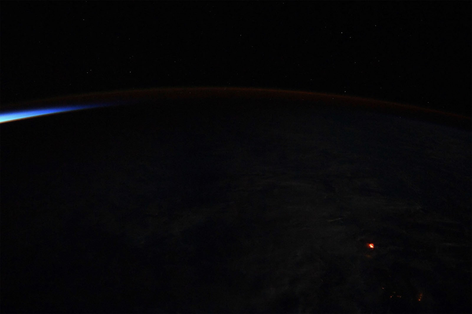 The lava glow from Hawaii&#039;s erupting Kilauea volcano shines an eerie orange in this nighttime photo taken by NASA astronaut Ricky Arnold on the International Space Station on June 20, 2018.