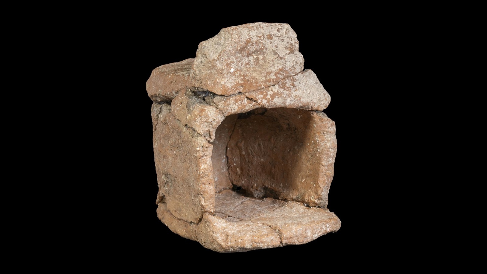A 3,300-year-old model temple made of clay against a black background