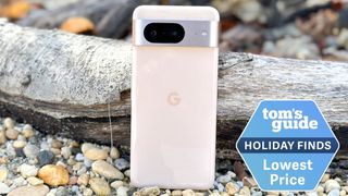 google pixel 8 in front of wood on the beach with lowestprice tag
