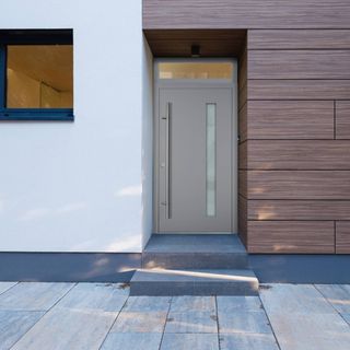 grey aluminium front door to white and wood house