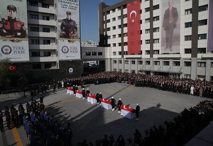 Turkish police officers stand guarded near the flag-draped coffins of police officers killed in yesterday's blast on December 11, 2016 in Istanbul, Turkey