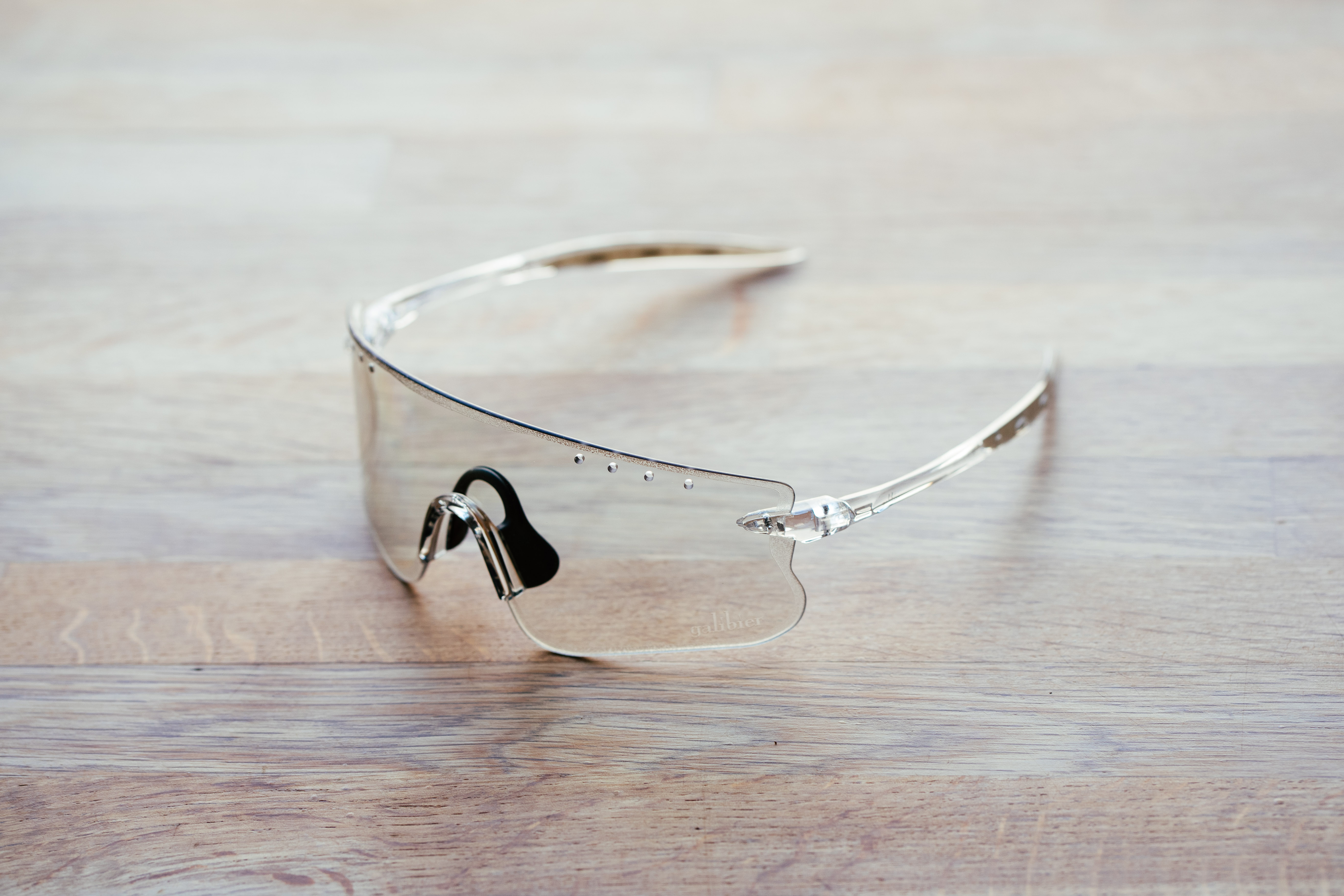 A clear pair of sports glasses on a wooden surface