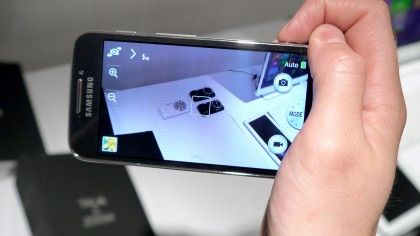 Samsung Galaxy S4 Zoom camera phone in hand showing camera app on screen