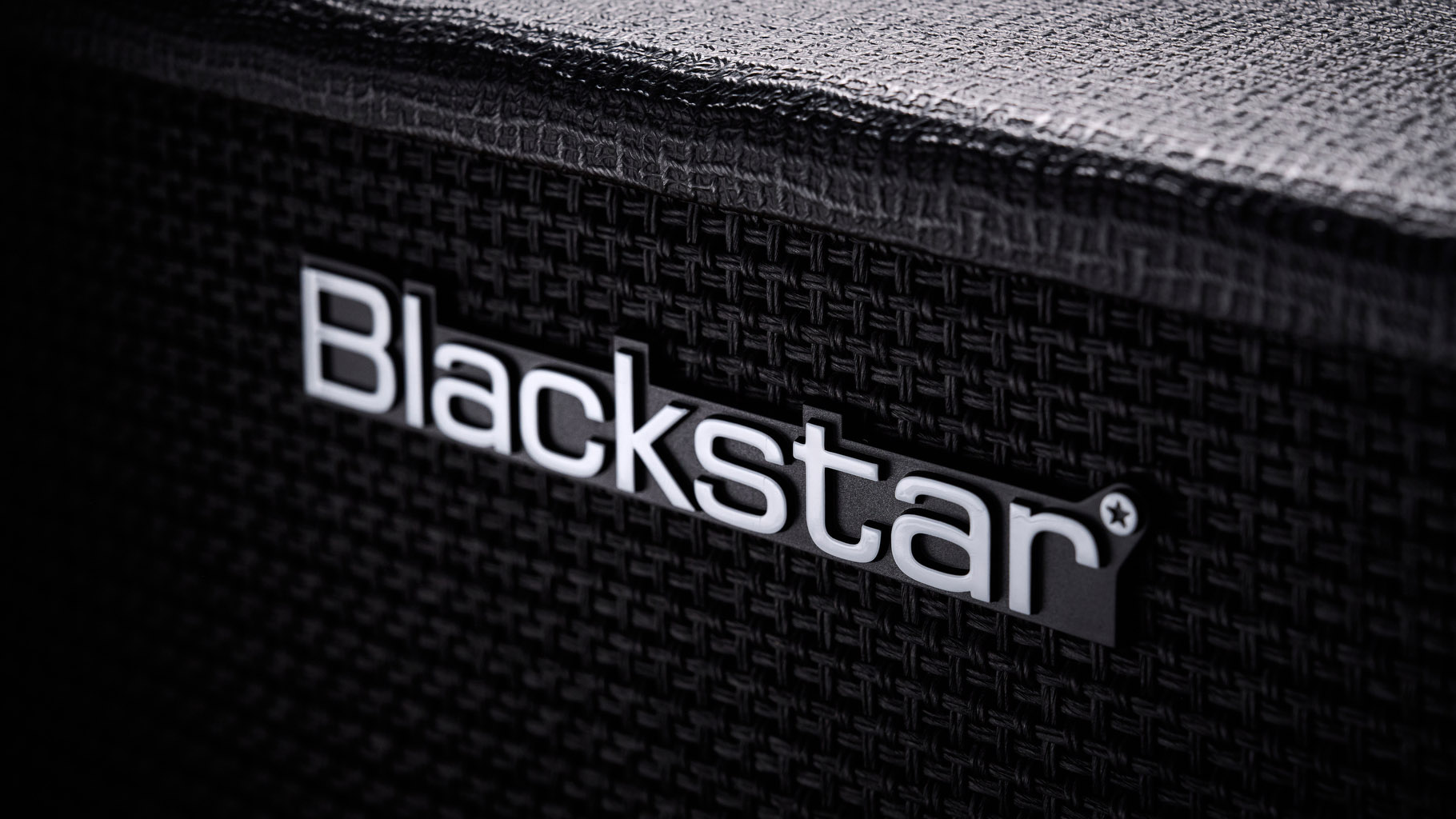 Blackstar Debut Bass 25: this compact little combo is finished in black with matching grille clothe and is photographed in close-up against a stone floor and weaved rug.
