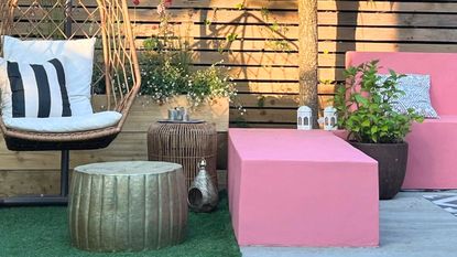 An outdoor patio with pink and rattan furniture