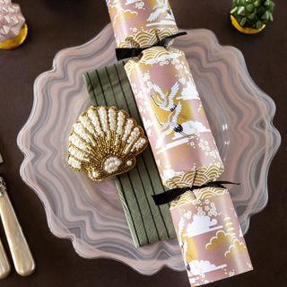 Pink and Green festive dinner table setup with shells and Christmas crackers