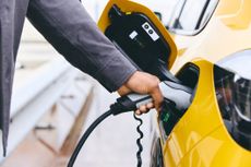 EV tariffs: A man charges up his electric car
