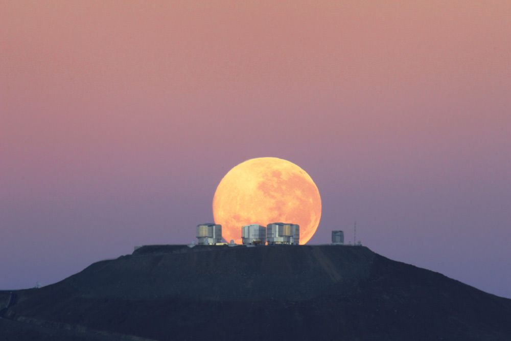 The full moon looks massive as it sets behind the Very Large Telescope in Chile&#039;s Atacama Desert, in this photo released on June 7, 2010. 