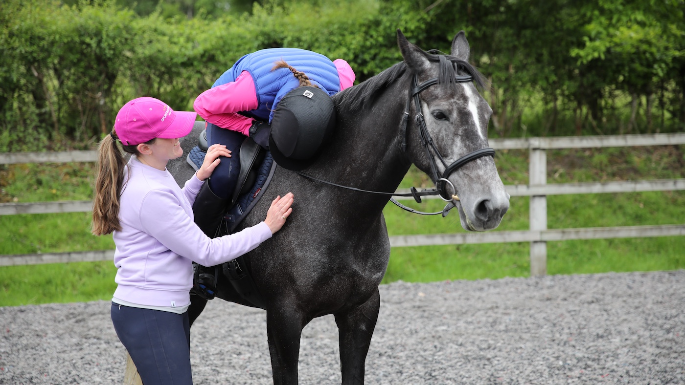 Friend comforting rider on horse