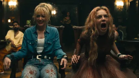 Kathryn Newton and Samara Weaving in Ready or Not 2, tied up to chairs and covered in blood.