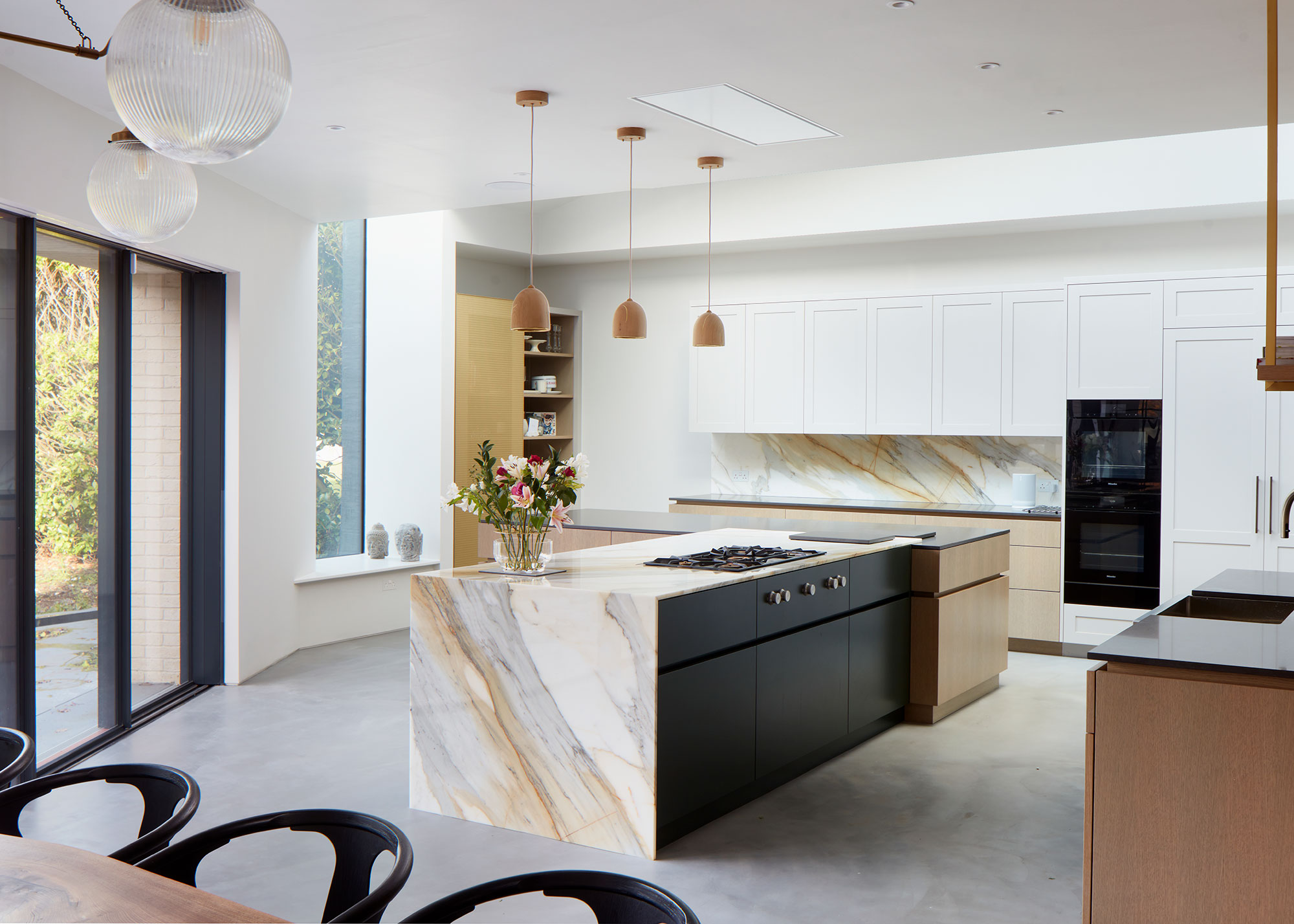kitchen extension with marble waterfall kitchen island and black framed glazing