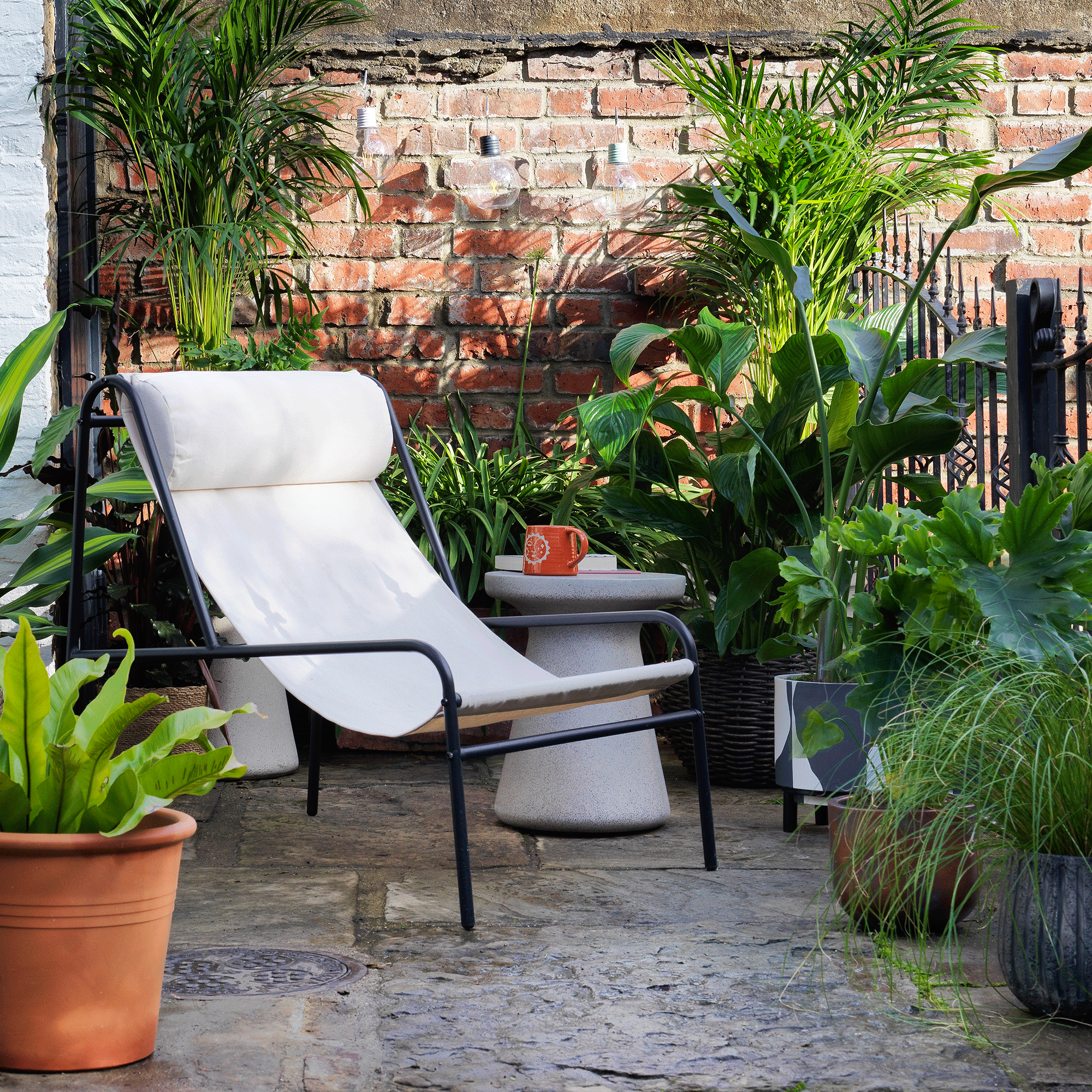 Lounge chair in white and black surrounded by house plants