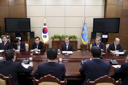 SEOUL, SOUTH KOREA - AUGUST 22: In this handout image provided by South Korean Presidential Blue House, South Korean President Moon Jae-in (C) listens to a report from officials related to th