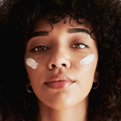 best night cream - A portrait of a young Black woman wearing a night cream on her skin