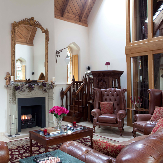 living room with leather sofa and armchair with mirror on wall
