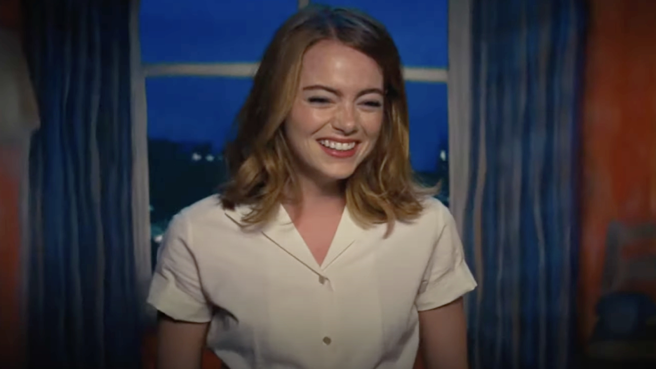 Emma Stone as Mia, smiling as the audience applauds after her solo performance in La La Land