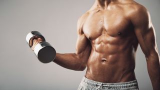 a photo of a man with strong abs holding a dumbbell