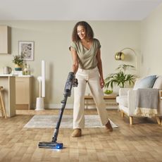 woman hoovering using shark device
