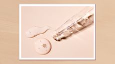 A close up of a glass pipette with drops of clear serum-like liquid on a beige backdrop/ in a beige, textured template 