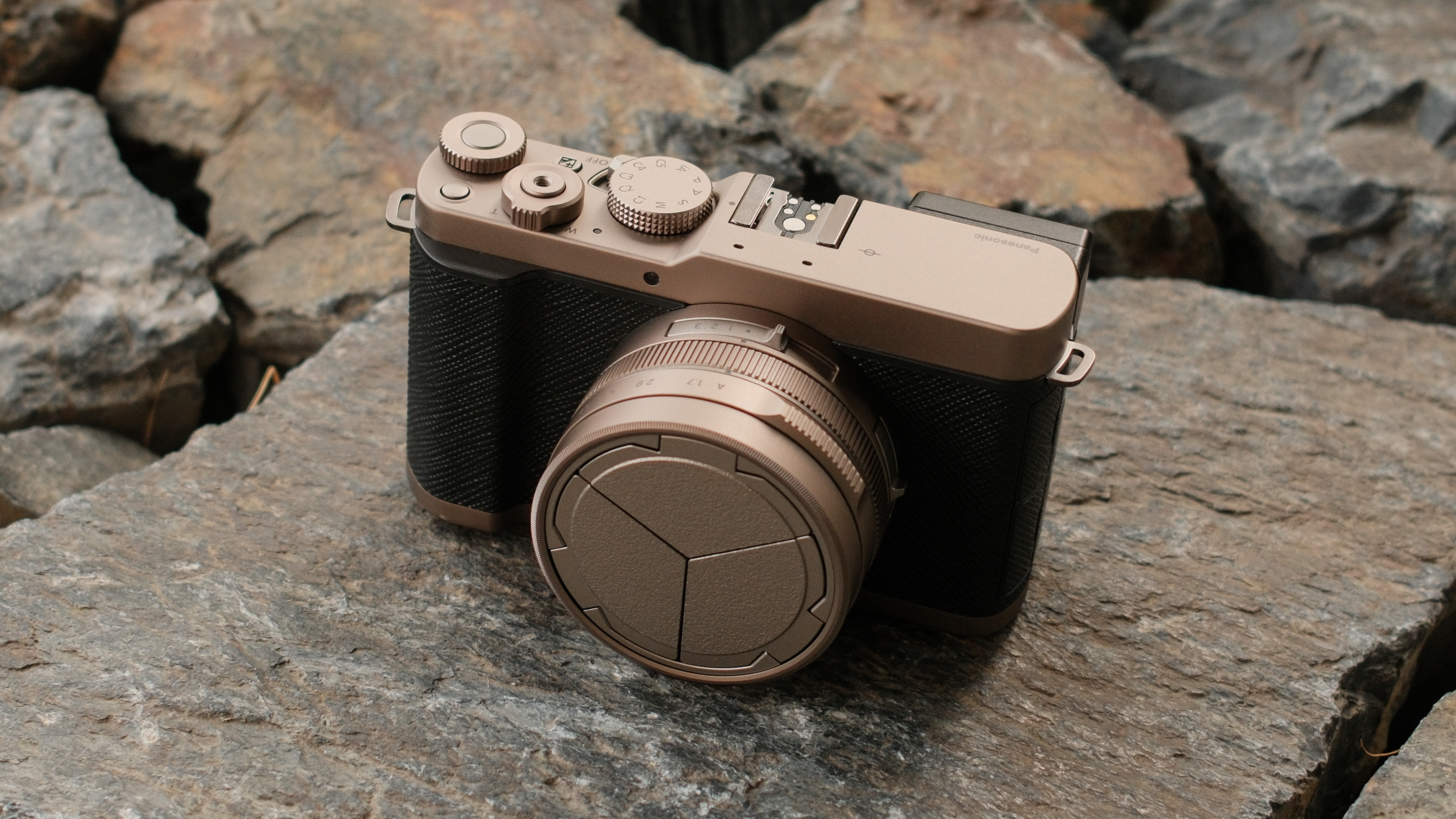Front view of the Panasonic Lumix L10 camera resting on rocks.