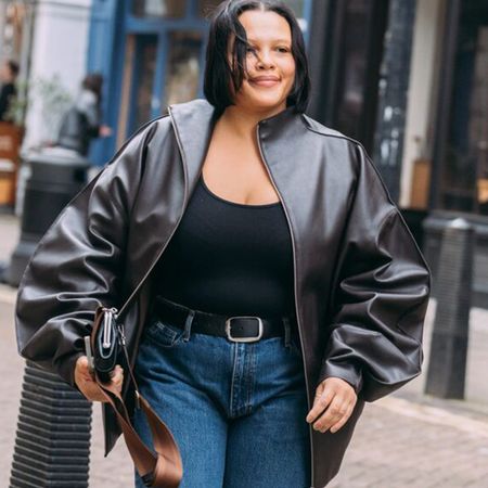 A guest attending shows during London Fashion Week fall/winter 2026 is wearing jeans with ankle boots.