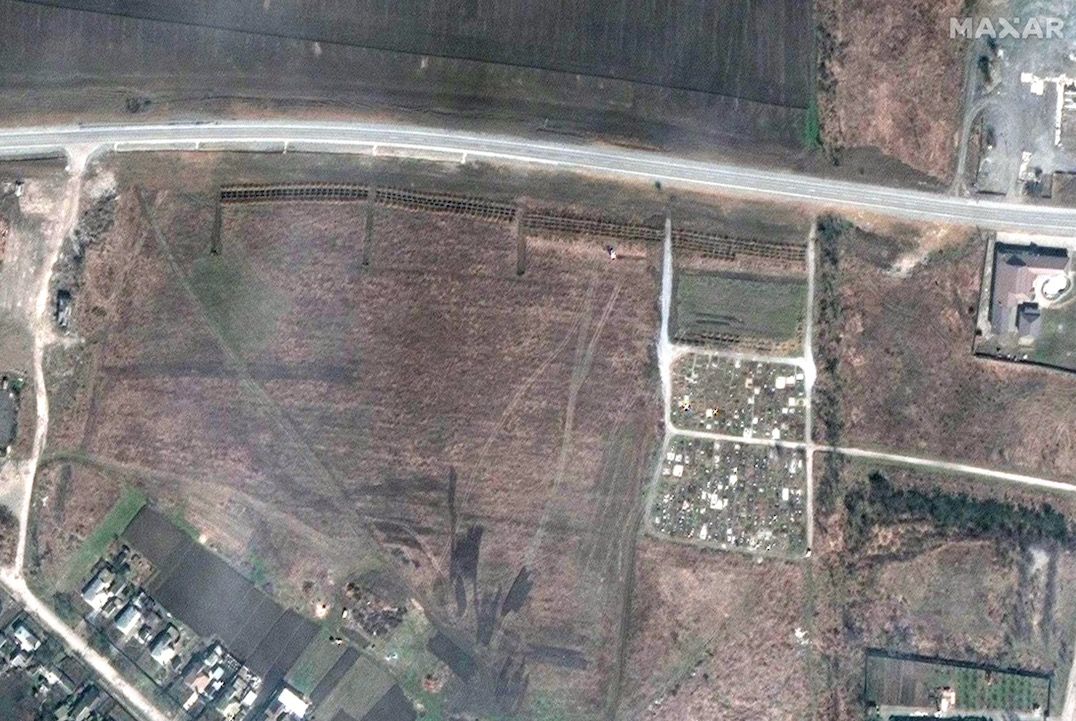 This photo, taken by Maxar Technologies&#039; GeoEye-1 satellite on April 3, 2022, shows a newly excavated mass grave (the rows near the center top, just under the road) in the Ukrainian town of Manhush, which is close to the besieged port city Mariupol.