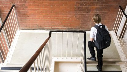 Child climbs stairs at secondary school